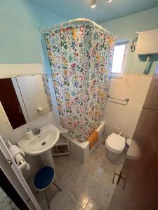a bathroom with a toilet sink and a shower curtain at Casa La Peña in Luarca