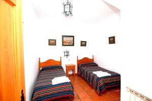 dos camas sentadas una al lado de la otra en una habitación en Apartamentos Turísticos Rural Los Tinaos en Bubión