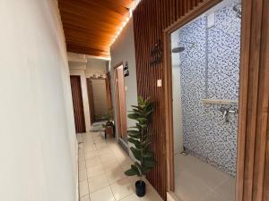 ein Badezimmer mit einer Dusche und einer Pflanze darin in der Unterkunft Buton Backpacker Lodge in Bandung + 58 Fotos