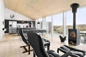 a living room with black chairs and a fireplace at 768-Snedsted-Somaerkevej-68 in Snedsted