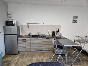 a kitchen with a refrigerator and a table with chairs at chambre coin zen in Fromelles