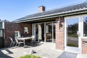 a brick house with a table and chairs on a patio at 991-Thisted-Liusborg-Sti-23 in Torsted