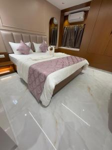 a bedroom with a large bed with a marble floor at Hotel Shloka in Thane