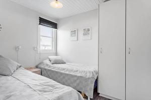 a bedroom with two beds and a cabinet at 417-Vestervig-Havnevej-1-lejl-17 in Vestervig +27 photos