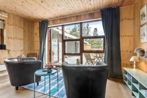 a living room with two chairs and a table and a window at 997-Thisted-Lyngstien-15-B in Torsted