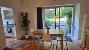 a kitchen and dining room with a wooden table and chairs at Les Platanes in Yvoire