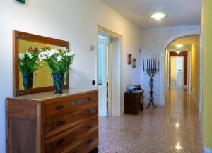 アルツィニャーノにあるAlbergo Corte di Emmaの鏡付きドレッサーと花が飾られた部屋
