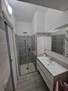 Un baño blanco con ducha y lavabo. en La Casa di Samu, en Àrbatax
