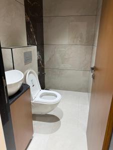 a bathroom with a toilet and a sink at Hotel Shloka in Thane