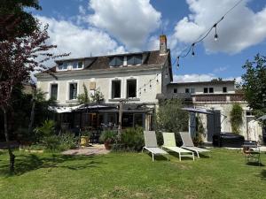 a house with three chairs in a yard at Villa du Beau Port in Cenon-sur-Vienne