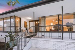 a home with large glass windows and a staircase at Sunbury large family home pet friendly airport in Sunbury