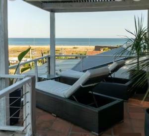 - un balcon avec un lit et une vue sur la plage dans l'établissement Cómoda casa vista espectacular zona Manantiales, à Balneario Buenos Aires