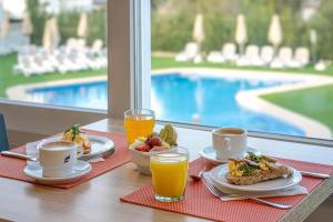 a table with plates of food and glasses of orange juice at THB Maria Isabel - Adults Only in Playa de Palma