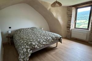 a bedroom with a bed and a large window at Le domaine de verteilhac la grange demile in Banassac +17 photos