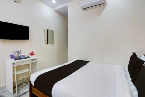 a bedroom with a bed and a tv on the wall at Super Collection O Sri Balaji Luxury rooms in Kondapur