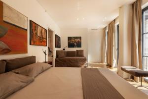 una camera da letto con un letto grande e un divano di Fra le righe - arte , design e interni siciliani a Catania