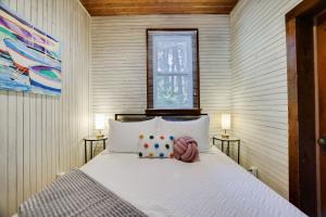 ein Schlafzimmer mit einem Bett mit Kissen und einem Fenster in der Unterkunft Heart's Desire, a Cottage With Stunning Lake Views in Effort