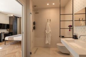 bagno con servizi igienici, lavandino e letto di Fra le righe - arte , design e interni siciliani a Catania