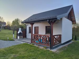 a small white house with a black roof at Dychnij Se in Myczków