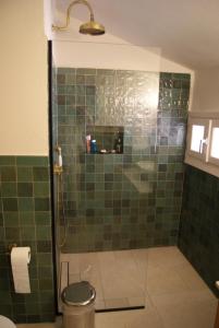 a bathroom with a shower with green tile at Villa Trypiti in Limenaria