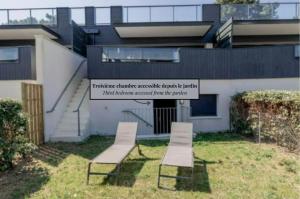 two chairs and a sign in front of a building at Résidence Les Suites Du Ferret in Cap-Ferret