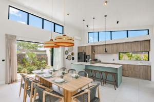 a kitchen and dining room with a wooden table and chairs at Eko Savannah by MJ Holidays in Tamarin