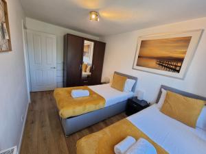 a hotel room with two beds and a window at 2 Bedrooms - 3 Beds - Free Parking - 168 in Stanwell