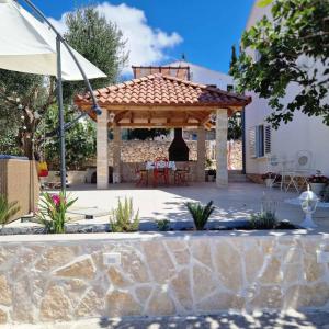 a gazebo with a table and chairs in a yard at Apartmani Meri in Ražanj
