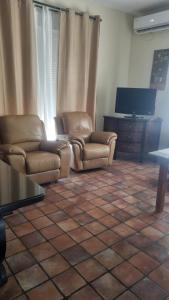 ein Wohnzimmer mit zwei Stühlen und einem Flachbildfernseher in der Unterkunft Casa Rural Valle in La Puebla de los Infantes