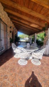 eine Gruppe weißer Stühle auf einer Terrasse in der Unterkunft Casa Rural Valle in La Puebla de los Infantes