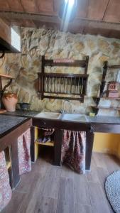 eine Küche mit Spüle und Steinwand in der Unterkunft Casa Rural Valle in La Puebla de los Infantes