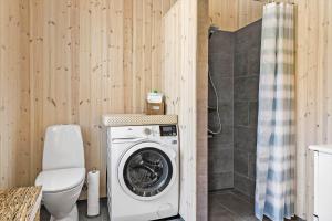 a bathroom with a washing machine and a toilet at 1051-Thisted-Skjaerbakken-57 in Torsted
