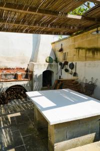 eine Küche mit Tisch und Pizzaofen in der Unterkunft Le Stanze del Monsignore in Novoli