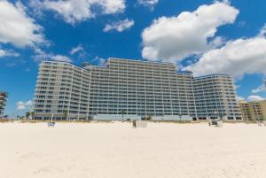 un grande edificio sulla spiaggia accanto a una spiaggia sabbiosa di Lighthouse 1004 a Gulf Shores