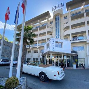 a white car parked in front of a hotel at Logis Hôtel & Spa Marina d'Adelphia in Aix-les-Bains +20 photos