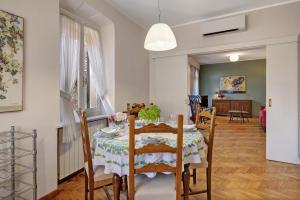 a dining room and living room with a table and chairs at I Portici Holiday Home in Cairo Montenotte