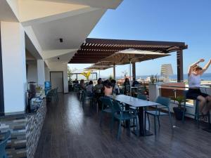a restaurant with people sitting at tables on a rooftop at Hotel Por Do Sol in Tarrafal