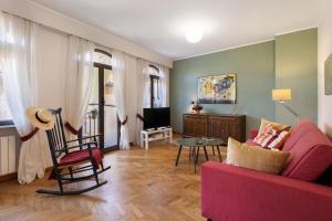 a living room with a pink couch and a tv at I Portici Holiday Home in Cairo Montenotte