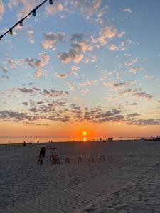 a group of people on the beach at sunset at Zviedru Nams in Liepāja