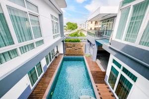 an apartment with a swimming pool between two buildings at Luxury Pure Modern Pool Villa 5Bed KTV Gym Nr BTS&Central in Bangkok