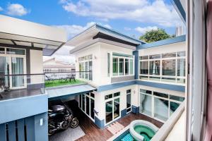 a view from the balcony of a house with a motorcycle at Luxury Pure Modern Pool Villa 5Bed KTV Gym Nr BTS&Central in Bangkok