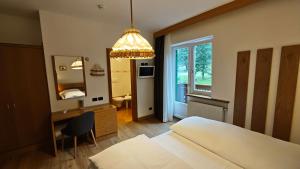 a bedroom with a bed and a desk and a mirror at Hotel Roy in Malga Ciapela