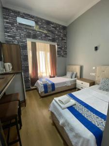 a hotel room with two beds and a window at Dünya Otel Adana in Seyhan
