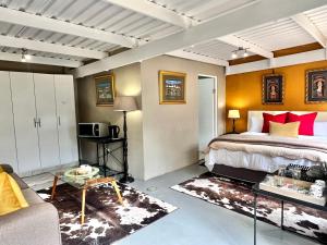 a bedroom with a king sized bed and a couch at Connemara Farm in Himeville