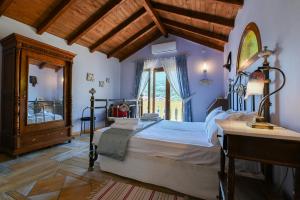 Casa al Castelllo - Traditional home in Parga في بارغا: غرفة نوم بسرير كبير ونافذة
