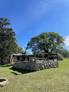 una casa con una pared de piedra y un árbol en Casas de Campo San Antonio JUJUY LLN, en La Toma
