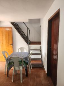 een tafel en stoelen in een kamer met een trap bij Apartamento Vca Paraguay in Villarrica +1 foto