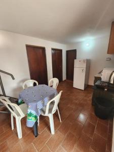 een keuken met een tafel, stoelen en een koelkast bij Apartamento Vca Paraguay in Villarrica