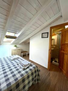 a bedroom with a bed with a checkered blanket at Flyhouse PARCHEGGIO AUTO BICI GRATUITO in Piana degli Albanesi