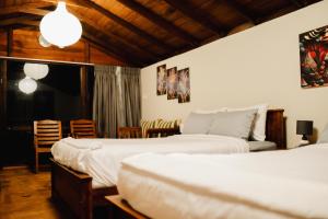 a bedroom with two beds and a table and chairs at O'Neill's Cottage in Dikkapitiya